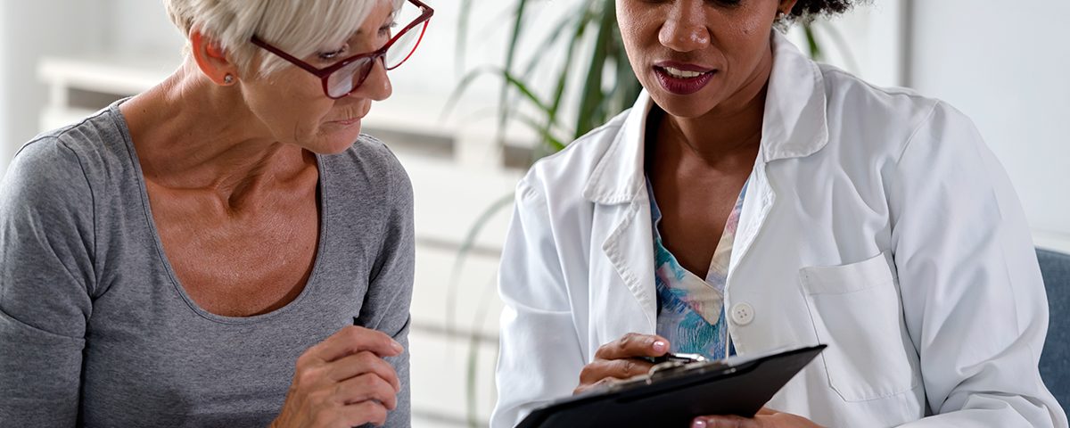 Patient and doctor talking over clipboard