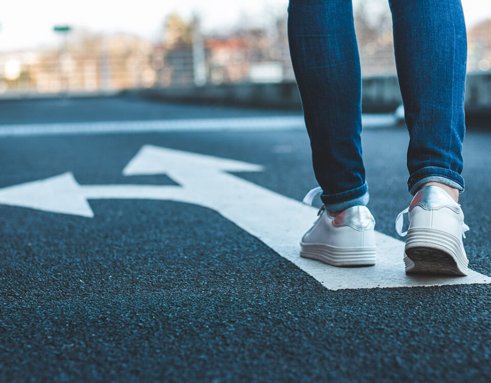 Person walking on directional sign